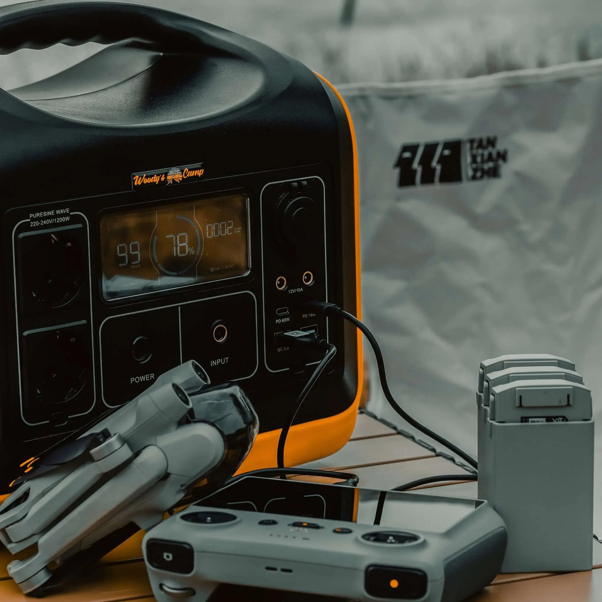 Camping accessories including power bank and gadgets for outdoor adventures on a table.
