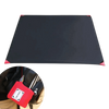 Tapis de camping noir compact avec des coins rouges à côté d'une petite pochette de transport rouge, idéal pour les activités de plein air comme les pique-niques et la randonnée.