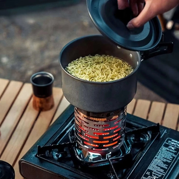 Cuisiner des nouilles sur un réchaud à gaz en inox portable pendant un camping.