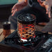 Chauffe-gaz portable mini en acier inoxydable sur réchaud, idéal pour le camping et les aventures en plein air, offrant chaleur compacte.