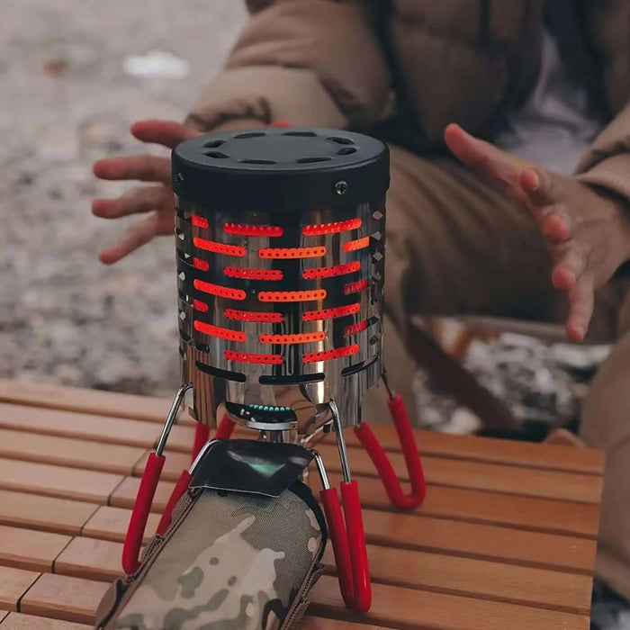 Réchaud à gaz portable en acier chauffant sur une table en bois lors d'une sortie en plein air.