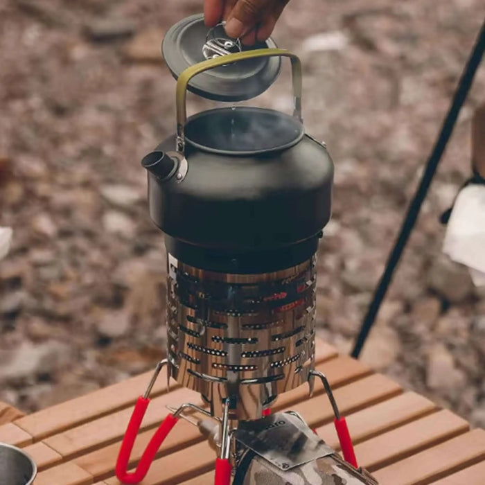 Réchaud à gaz portable en acier inoxydable sur une table en bois, idéal pour le camping en plein air.