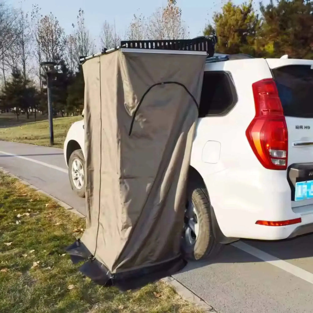 Portable shower and toilet tent mounted on a vehicle for outdoor camping, providing privacy and convenience during road trips.