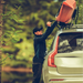 Un homme fixe une tente de toit avec un écrou universel M8 sur un SUV dans un cadre forestier.