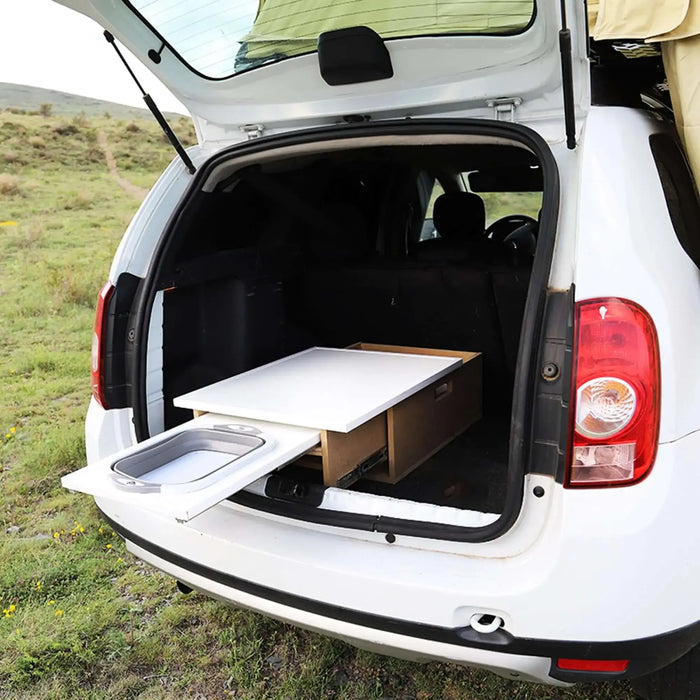 Système de cuisine de camping en boîte dans le coffre de la voiture, transformant le véhicule en mini-van avec un espace de rangement et un comptoir coulissant.