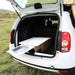 Système de cuisine de camping en boîte dans le coffre de la voiture, transformant le véhicule en mini-van avec un espace de rangement et un comptoir coulissant.