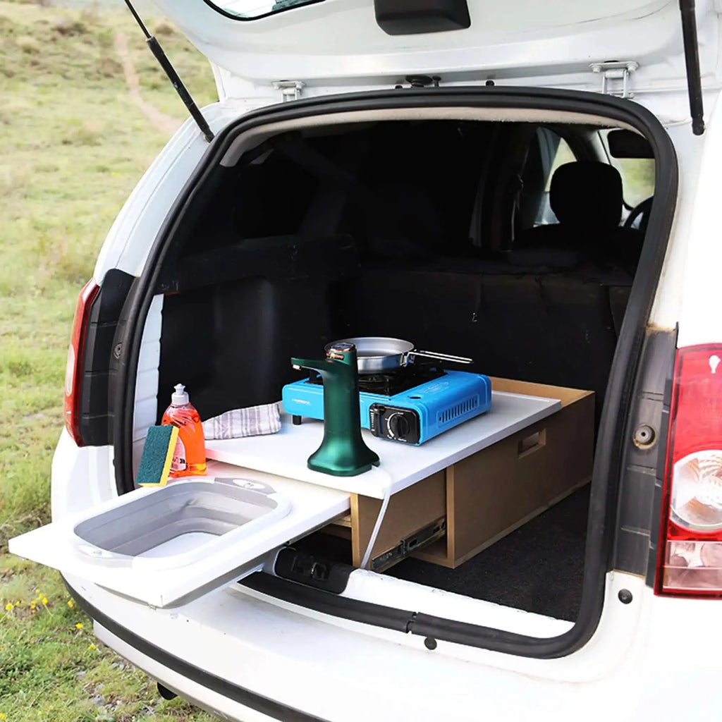 Box camping kitchen setup in car trunk with portable stove and sink, perfect for transforming vehicles into mini vans for travel.