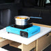 Boîte de cuisine portable pour le camping en voiture avec réchaud et casserole, conçue pour les petits coffres de véhicule. La boîte offre du rangement et un montage facile.