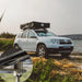 SUV avec une tente de toit fixée à l'aide d'un kit de écrous antivol M8 près d'un lac, mettant en avant des fixations robustes en acier inoxydable et une caractéristique de sécurité.