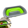 Passoire pliable en silicone verte avec poignées réglables, idéale pour le camping, vue de dessus avec des légumes frais.