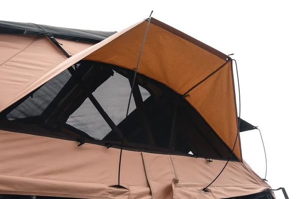 Une tente de toit souple pour 2-3 personnes montée sur une voiture blanche en pleine nature, parfaite pour un road trip et des aventures en plein air.