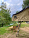 louer materiel camping table chaise montpellier location herault 34000 woodys camp Table de camping en bois pliable installée en extérieur avec des chaises, des boissons et de la nourriture, mettant en avant un design durable pour des repas confortables en plein air.