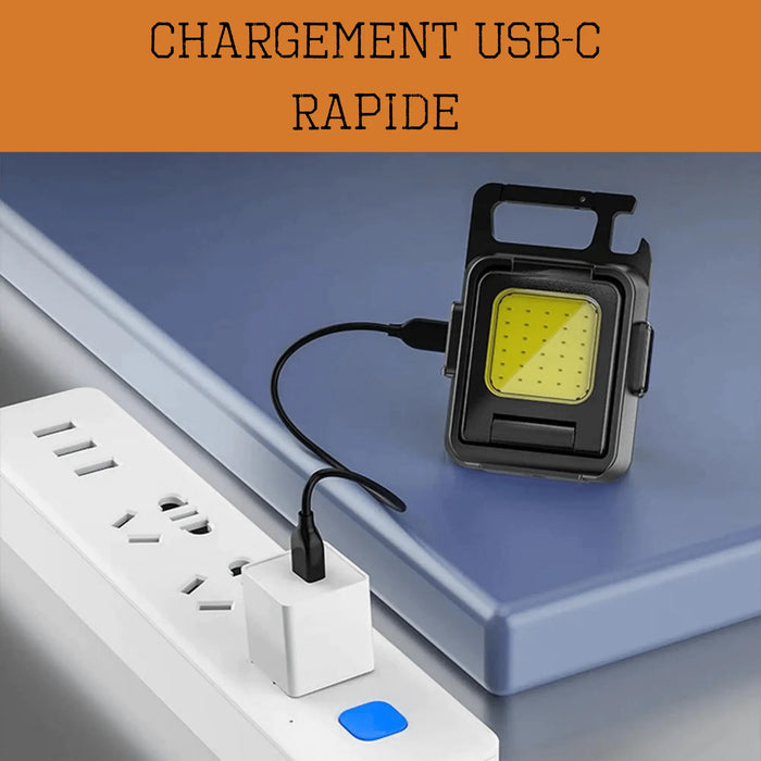 Mini lampe de poche LED avec chargeur USB-C rapide, posée sur une table, connectée à une prise électrique, compacte et puissante.