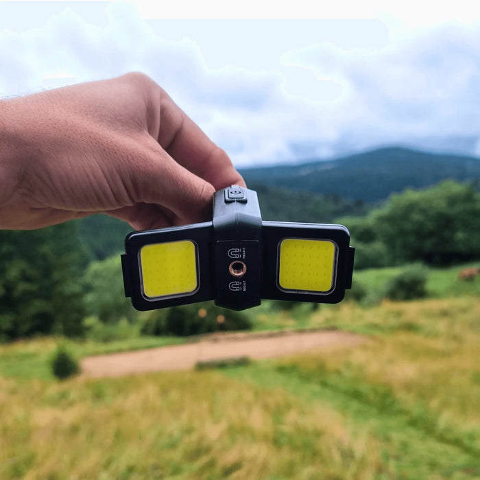 Une personne tenant une mini lampe de poche LED en plein air, mettant en avant ses caractéristiques compactes et ultra lumineuses pour des aventures nocturnes.