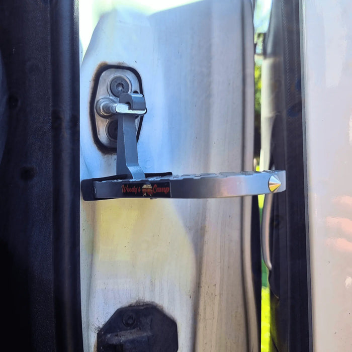 Gros plan d'un accessoire d'escalier de tente de toit fixé à la charnière de la porte de la voiture pour un accès facile aux tentes de toit.