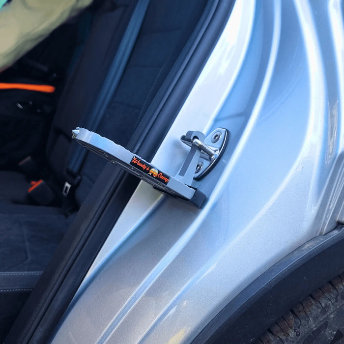 Marchepied pour tente de toit fixé à la portière d'une voiture, offrant un accès sécurisé et facile pour le camping.