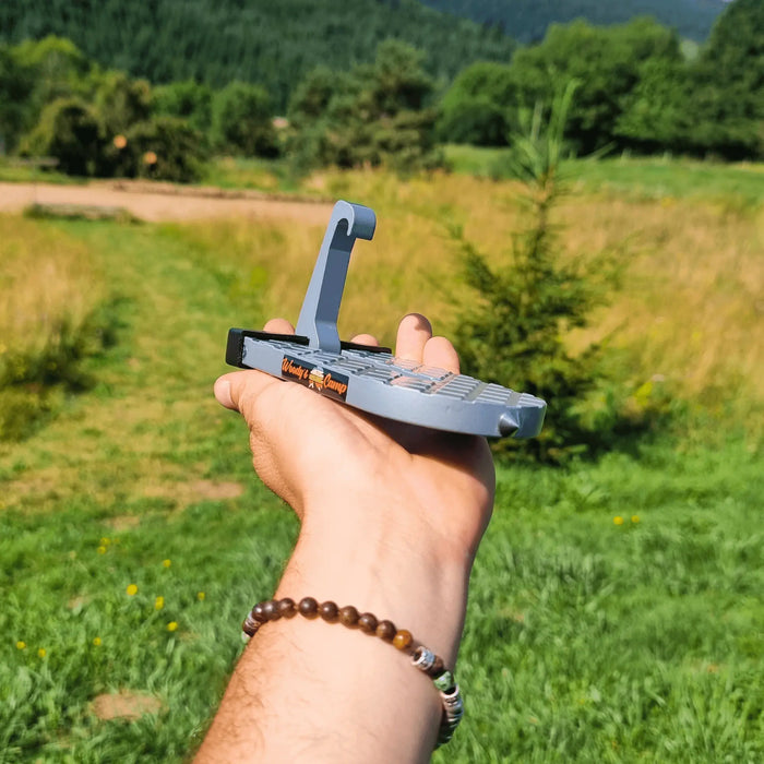 Tente de toit portable tenue à la main avec un fond extérieur pittoresque, conçue pour un accès facile aux configurations de camping en hauteur.