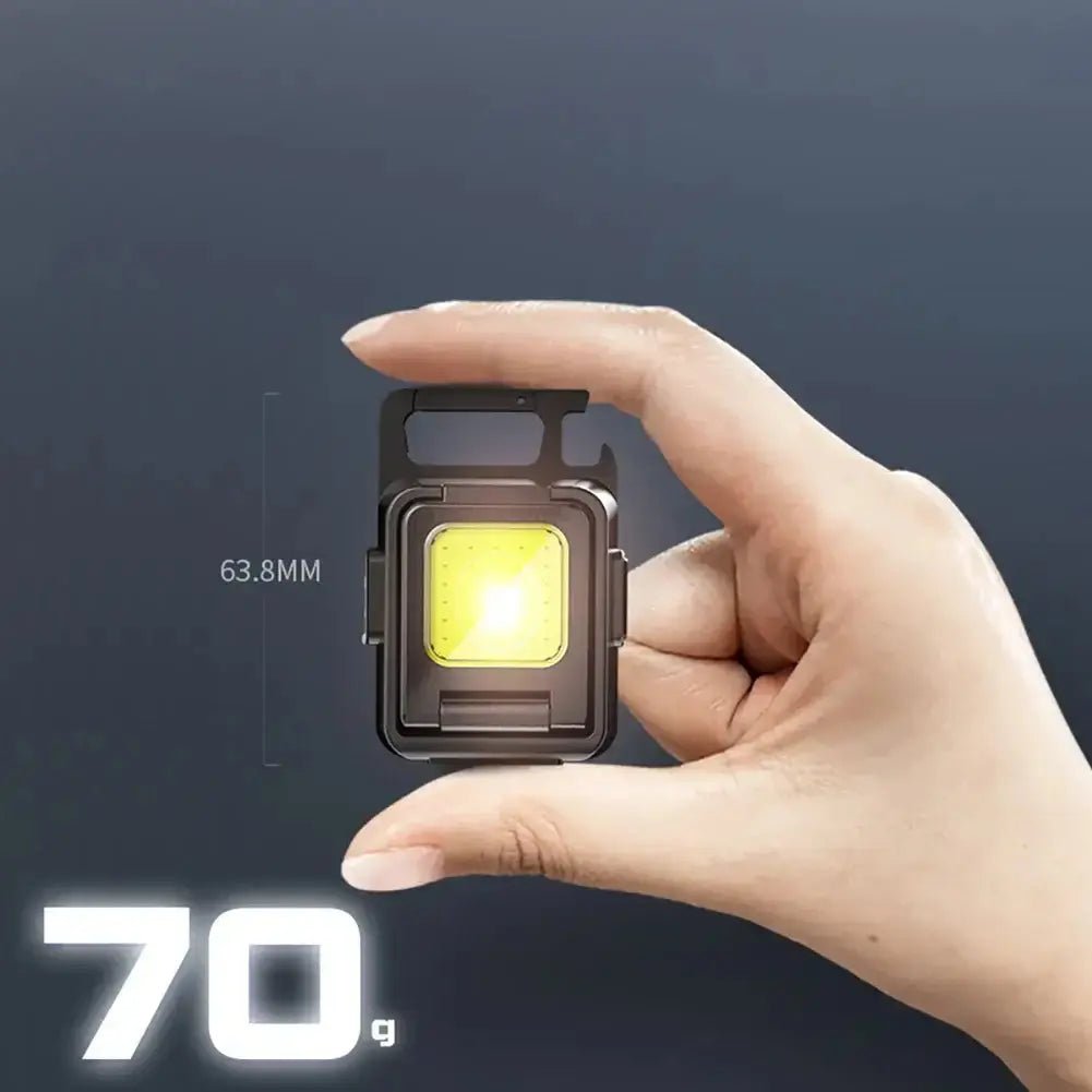 Hand holding compact mini LED flashlight weighing 70g, measuring 63.8mm, powerful light source for adventures.