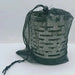 Chauffage à gaz en acier portable dans un sac en maille, idéal pour le camping et les activités en plein air, offrant un confort chaleureux dans un design compact.