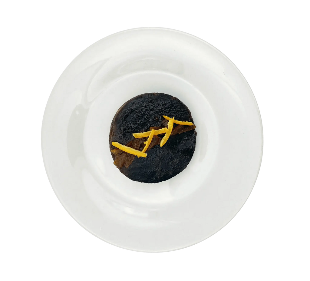 Vue de dessus d'un dessert au chocolat et à l'orange en génoise de France sur une assiette blanche, idéal pour les sorties en camping.