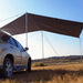 Des poteaux de tente réglables soutenant un auvent de voiture dans un cadre ensoleillé, idéal pour le camping et les road trips.