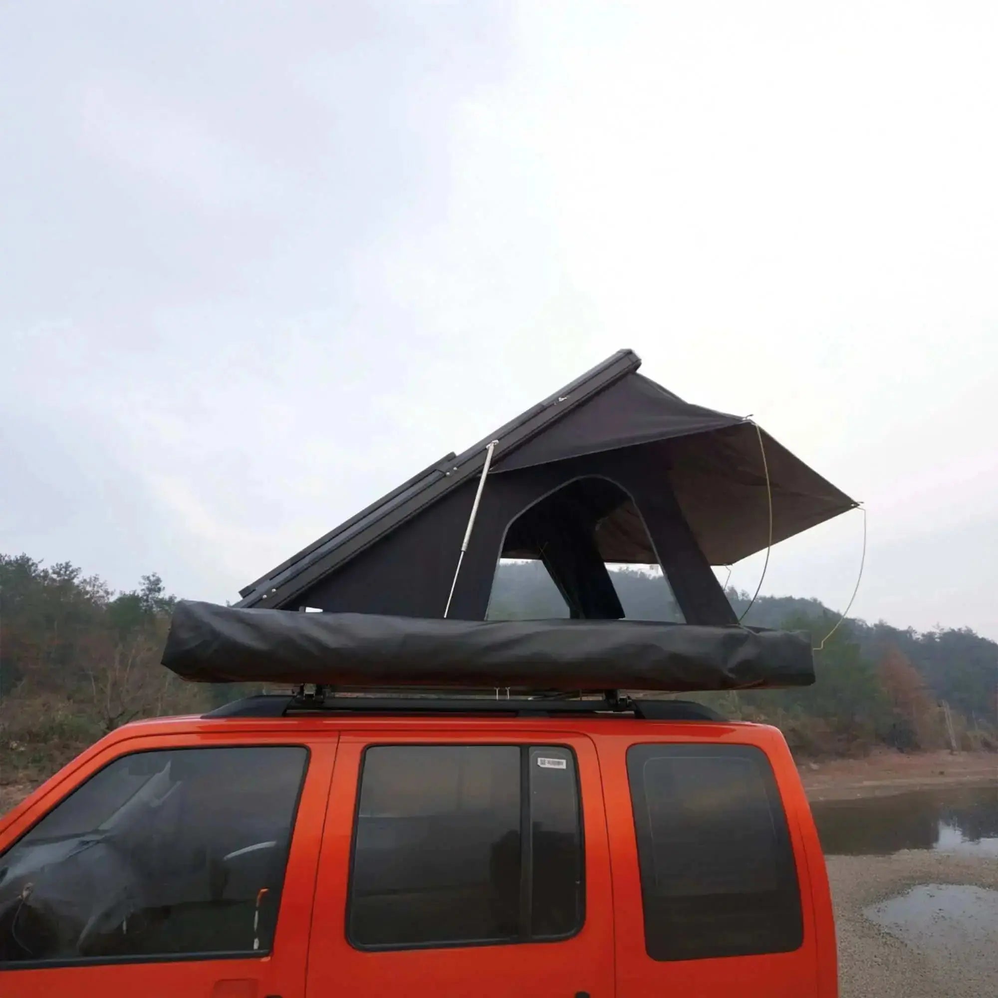 Orange vehicle with rooftop tent installed, indicating readiness for outdoor camping and travel adventures.