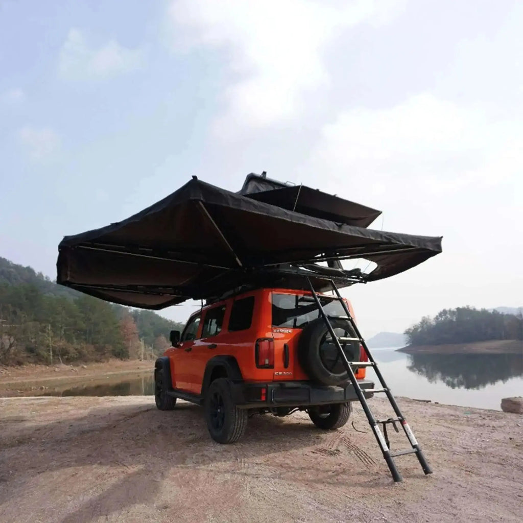 Orange 4x4 vehicle with deployed 360° 4-arm autoportant awning with integrated LEDs, lakeside camping setup.