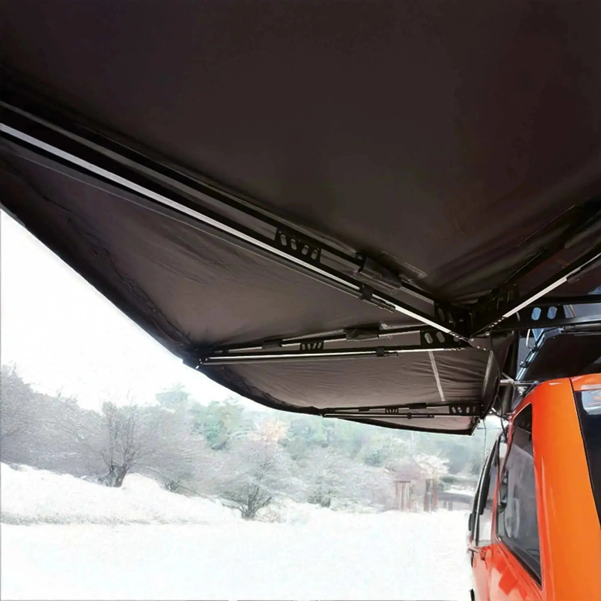 Self-supporting 360° black awning with integrated LEDs and strong aluminum arms attached to an orange vehicle in a snowy landscape.