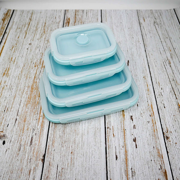 Une pile de 5 boîtes à lunch en silicone pliable de différentes tailles sur une surface en bois.