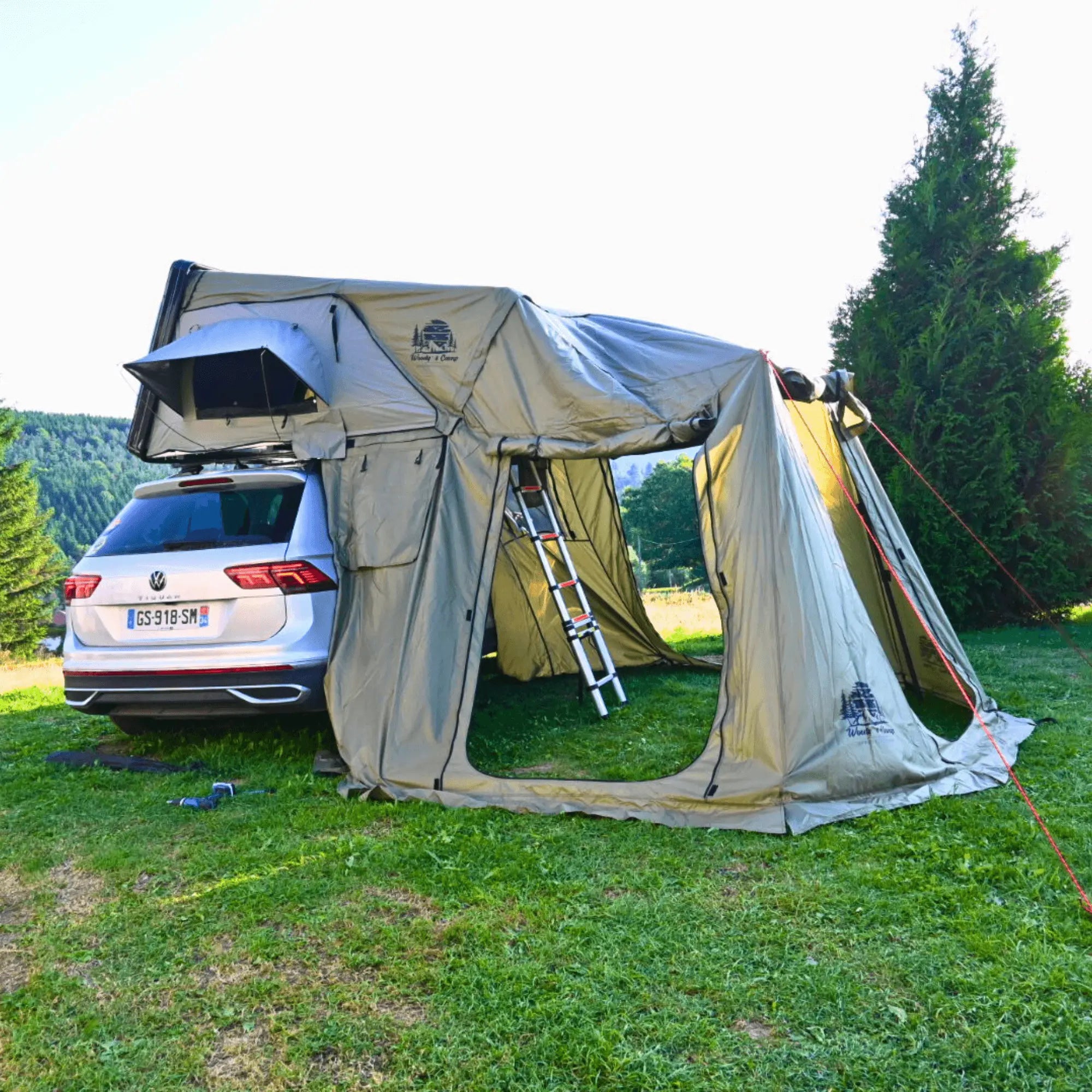 Annexe pour tente de toit rigide attachée à une voiture, offrant un espace de vie supplémentaire pour 2 à 3 personnes en plein air.