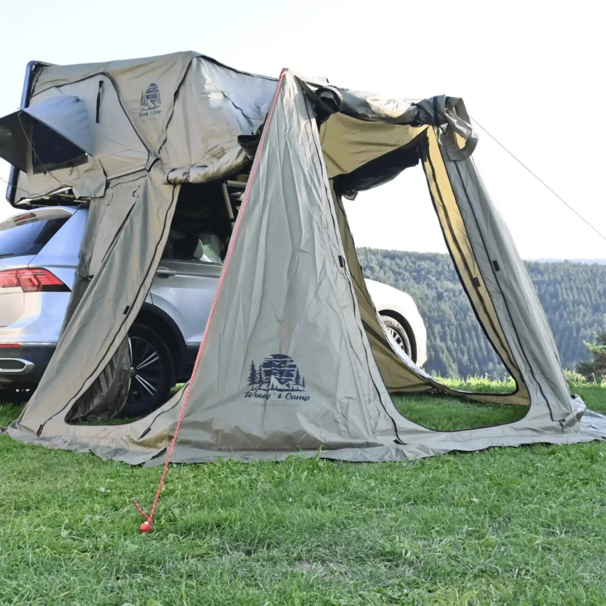 Annexe pour tente de toit rigide pour 4-5 personnes, offrant espace privé avec ouvertures, fixée à une voiture, en pleine nature.