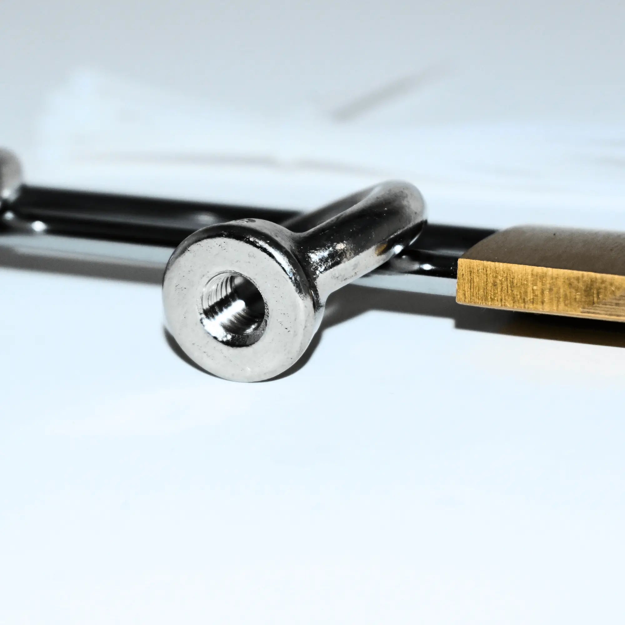 Close-up of a rooftop tent security kit with a steel ring and padlock for theft protection.