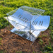 Ensemble de grille en acier inoxydable pliable installé sur l'herbe, idéal pour la cuisson en plein air et le camping.