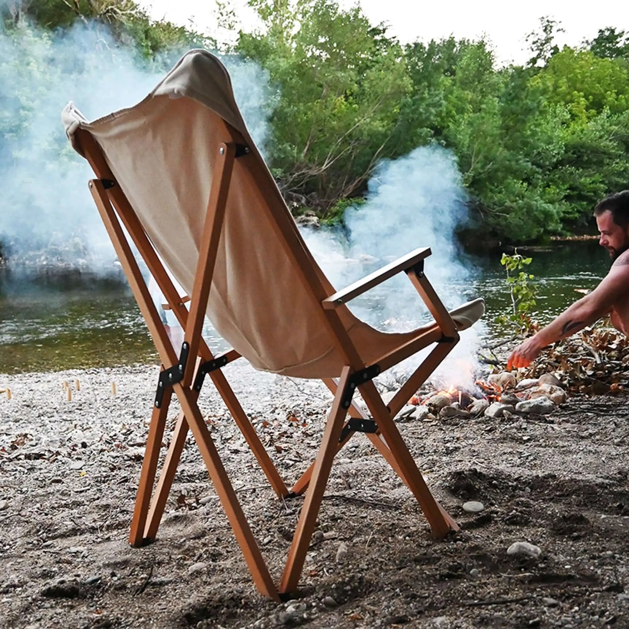 Chaise pliante en bois XL beige au bord de la rivière, idéale pour camping et détente en plein air.