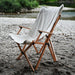 louer materiel camping table chaise montpellier location herault 34000 woodys camp Table de camping en bois pliable installée en extérieur avec des chaises, des boissons et de la nourriture, mettant en avant un design durable pour des repas confortables en plein air.