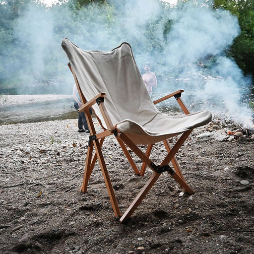 Chaise pliante en bois XL beige sur une plage, idéale pour le camping, les pique-niques et la détente, fabriquée en bois massif et tissu résistant.