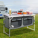 cuisine de camping pliante, meuble cuisine camping, table camping avec rangement, armoire camping pliable, cuisine outdoor portable, table de camping aluminium, meuble vanlife cuisine, équipement camping cuisine, table barbecue extérieure