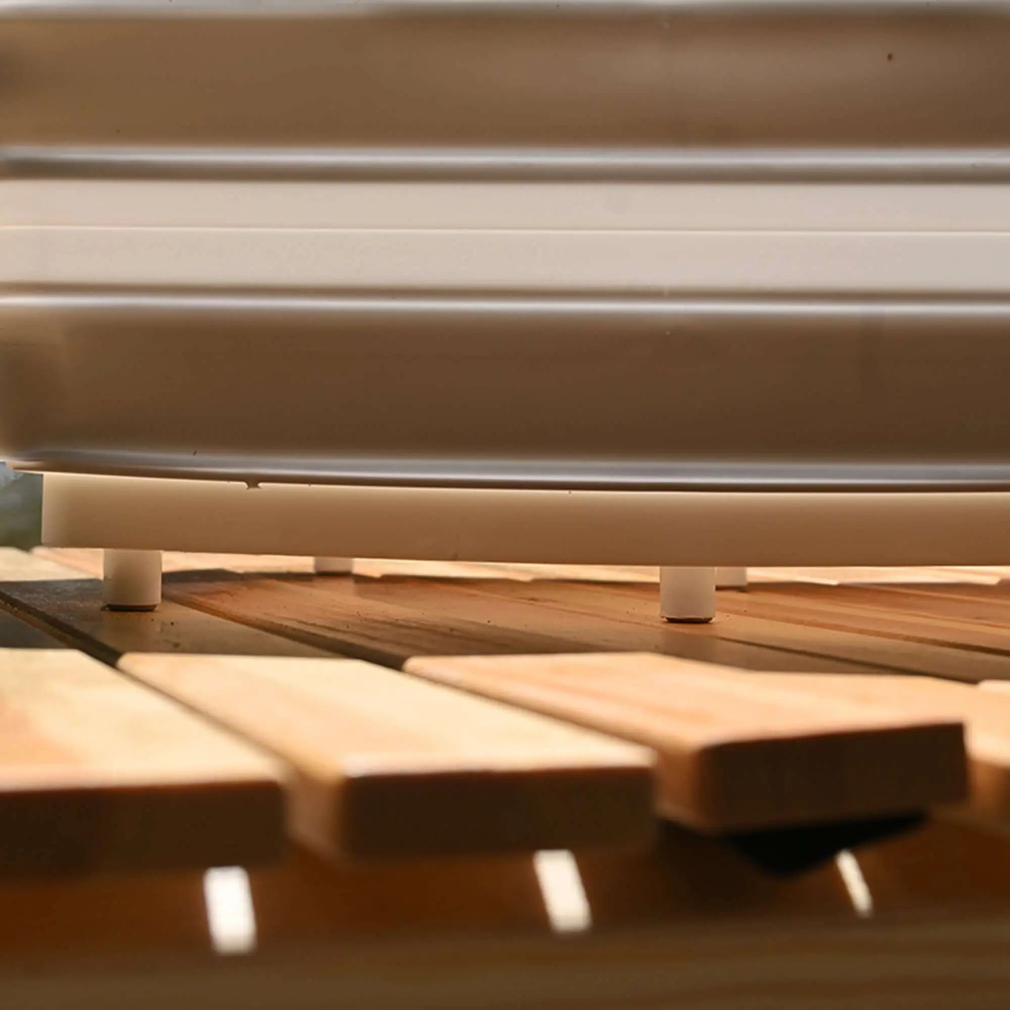 Close-up of a portable foldable silicone camping sink and cutting board on a wooden surface outdoors.