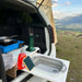 Évier pliable en silicone pour camping installé dans un van avec vue sur les montagnes, idéal pour la cuisine en plein air.