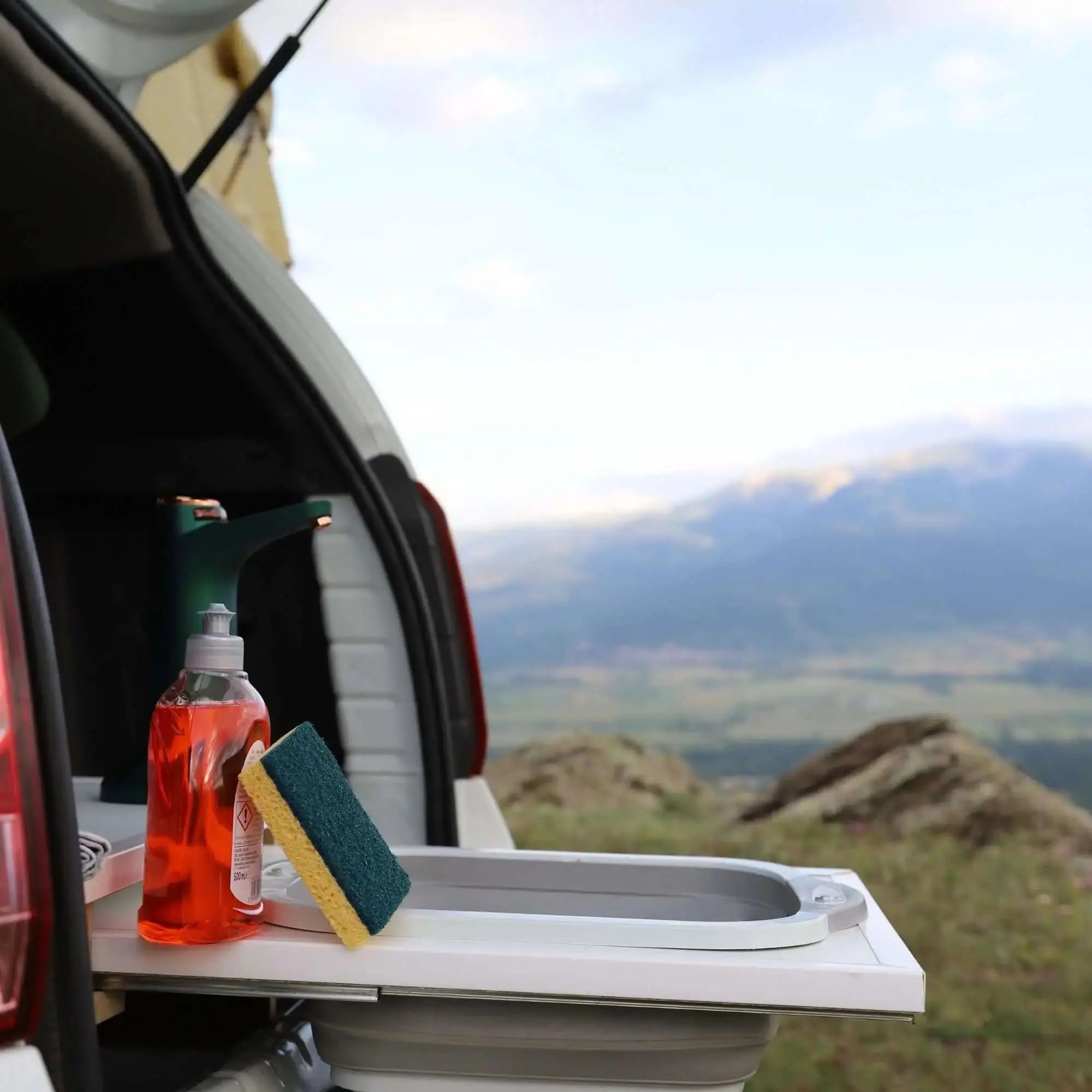 Camping silicone collapsible sink and cutting board on van with mountain view