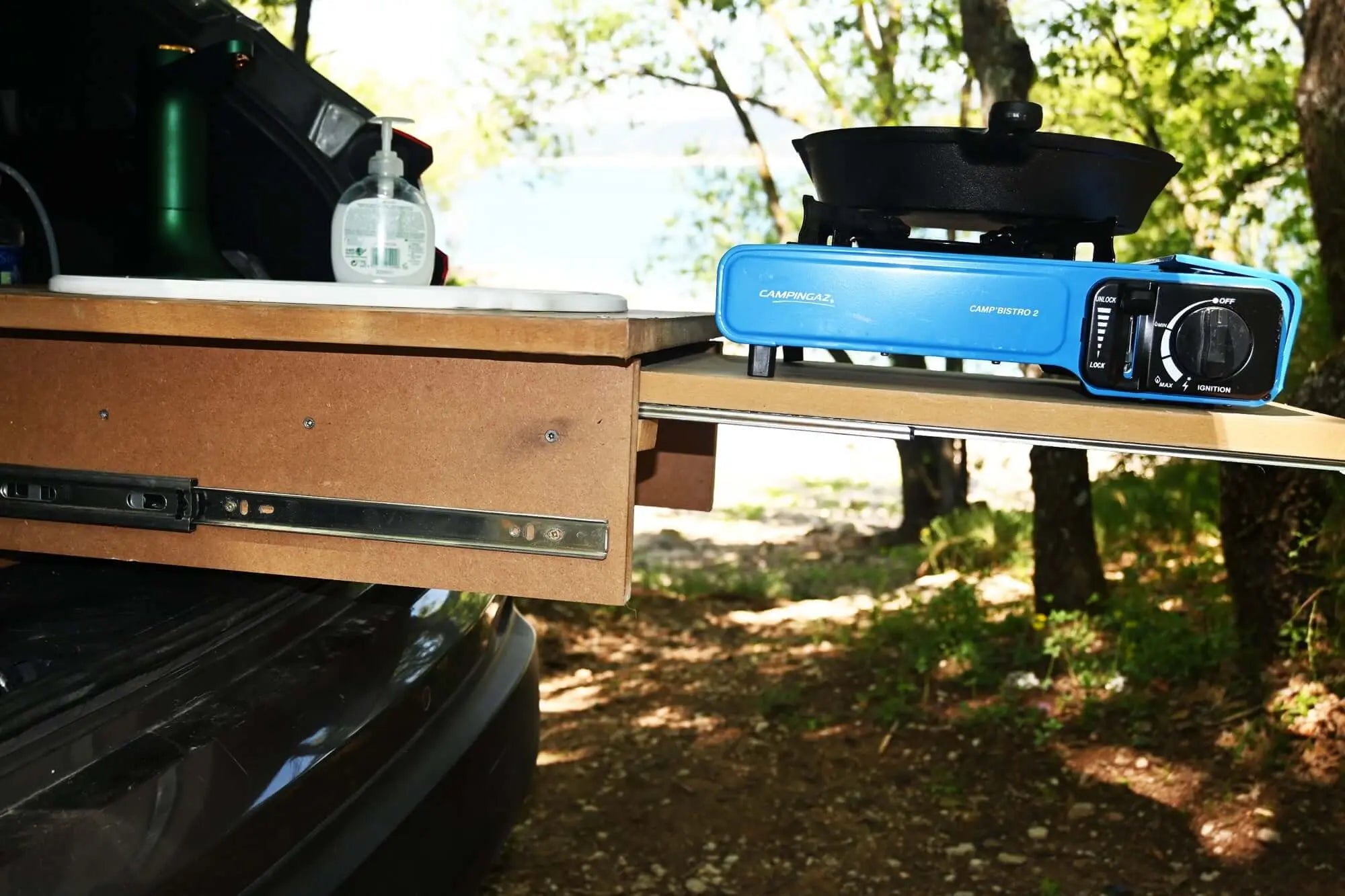 Portable camping stove on extended drawer with ball bearing slide, scenic outdoor setting