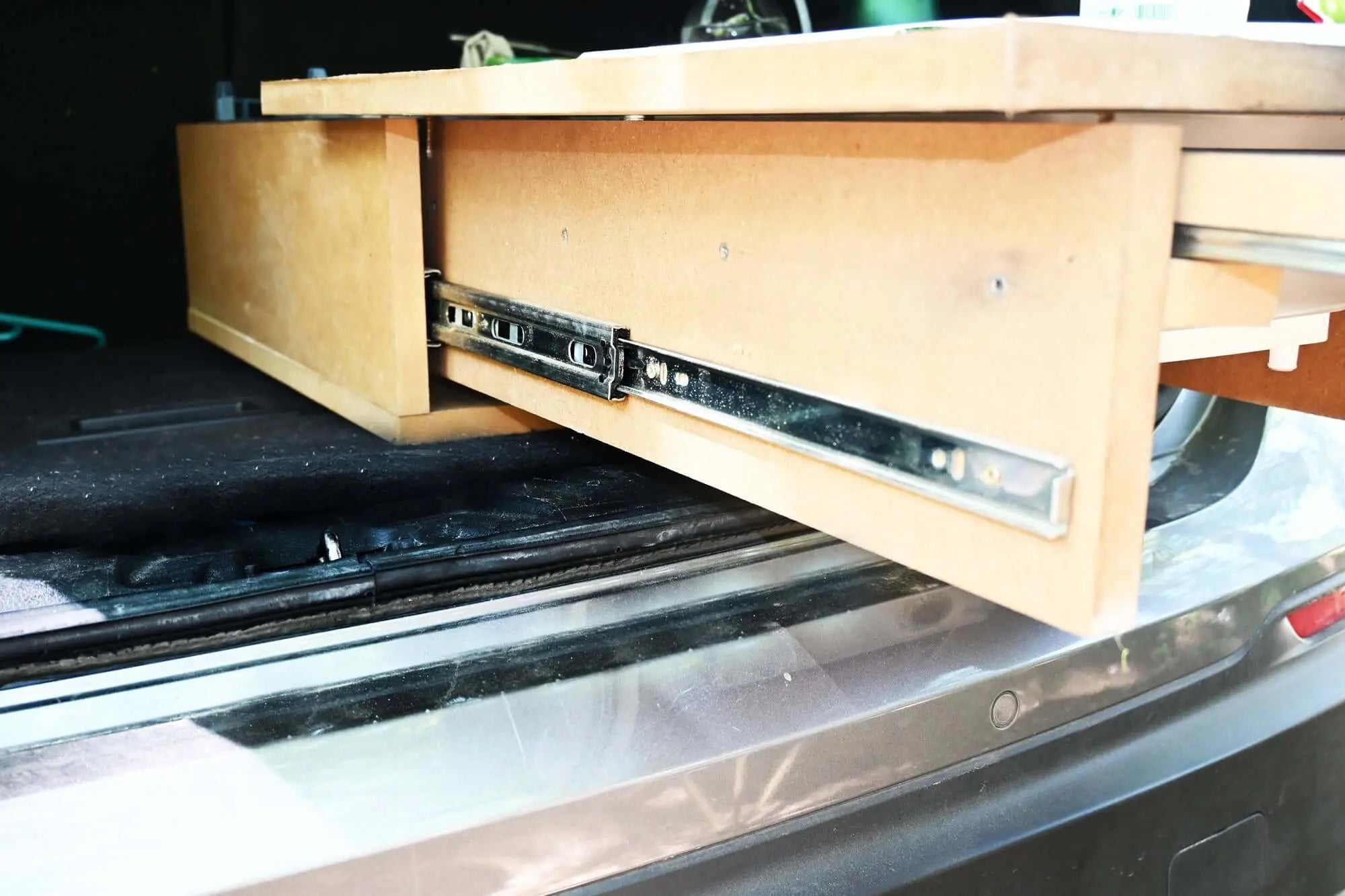 Heavy-duty ball bearing drawer slide extended from a wooden cabinet, showcasing smooth extension and robust construction.
