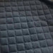 Gros plan sur un matelas en mousse à mémoire de forme matelassé pour tente de toit, mettant en avant un tissu texturé pour un confort accru lors du camping.
