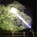 Lampe frontale haute puissance illuminant la forêt de nuit, idéale pour le camping sauvage et les activités de plein air avec 90 000 lumens.