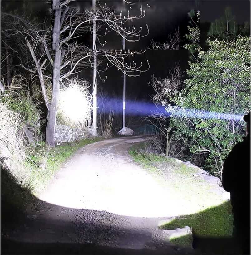Ultra-bright headlamp illuminating a forest path, perfect for camping and outdoor adventures with 90,000 lumens and 500-meter range.