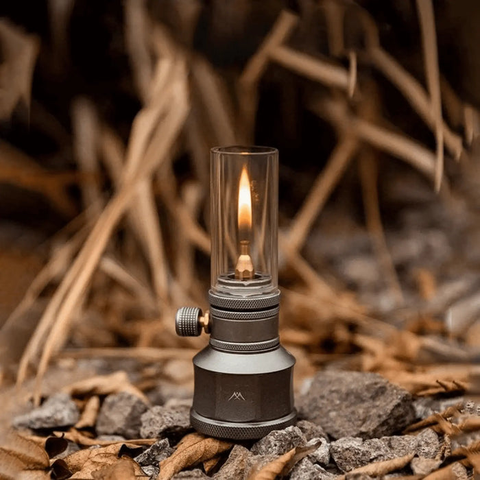 Lampe lanterne à gaz de camping rechargeable avec flamme allumée, idéale pour créer une ambiance chaleureuse en plein air.