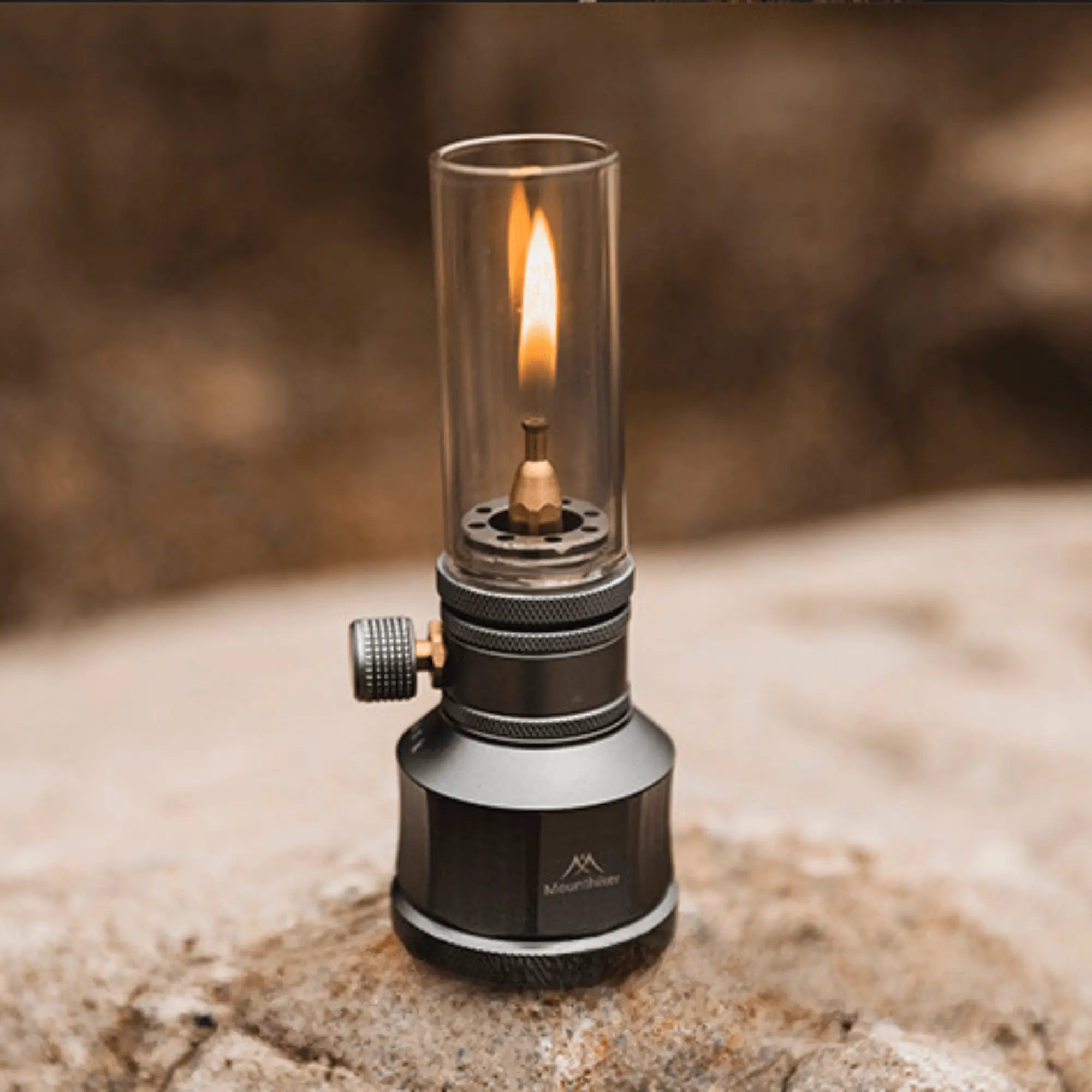 Camping gas lantern on a rock, rechargeable and customizable for warm outdoor lighting during hiking, road trips, or camping.