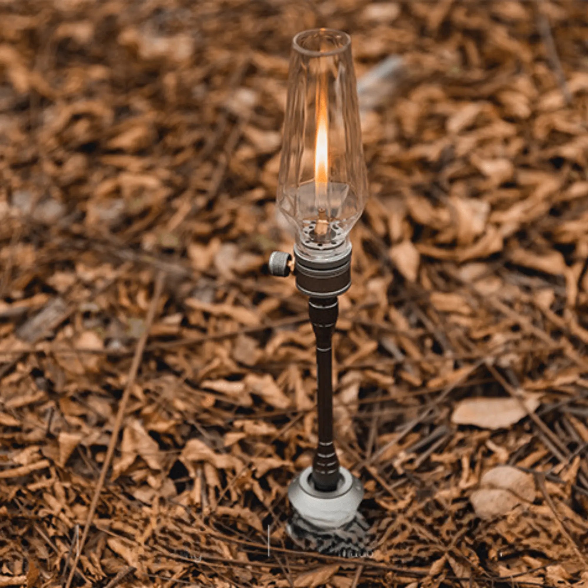 Rechargeable camping gas lantern on forest floor, providing warm light for outdoor adventures and creating a cozy atmosphere under the stars.