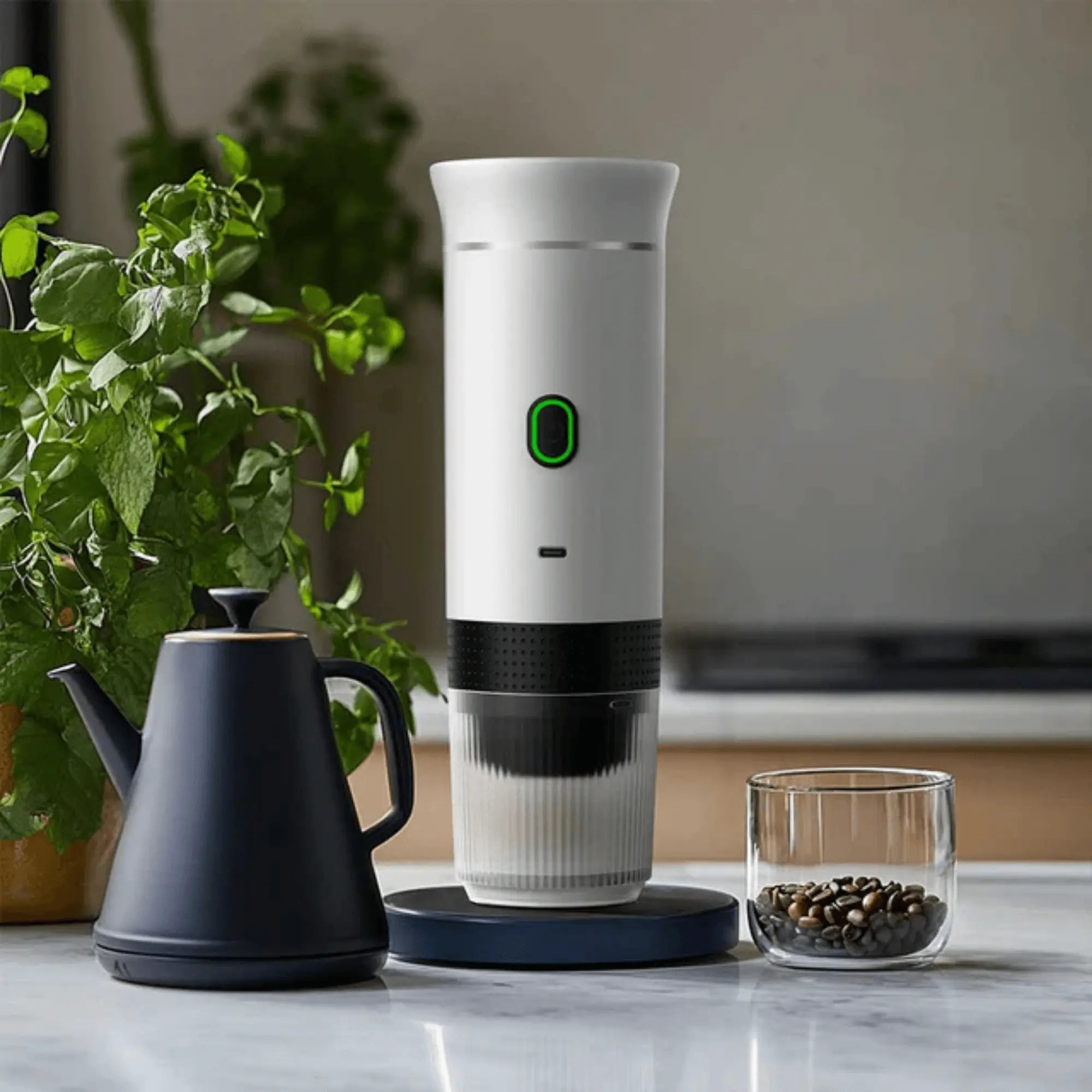Portable electric coffee machine on kitchen counter with coffee beans and kettle.