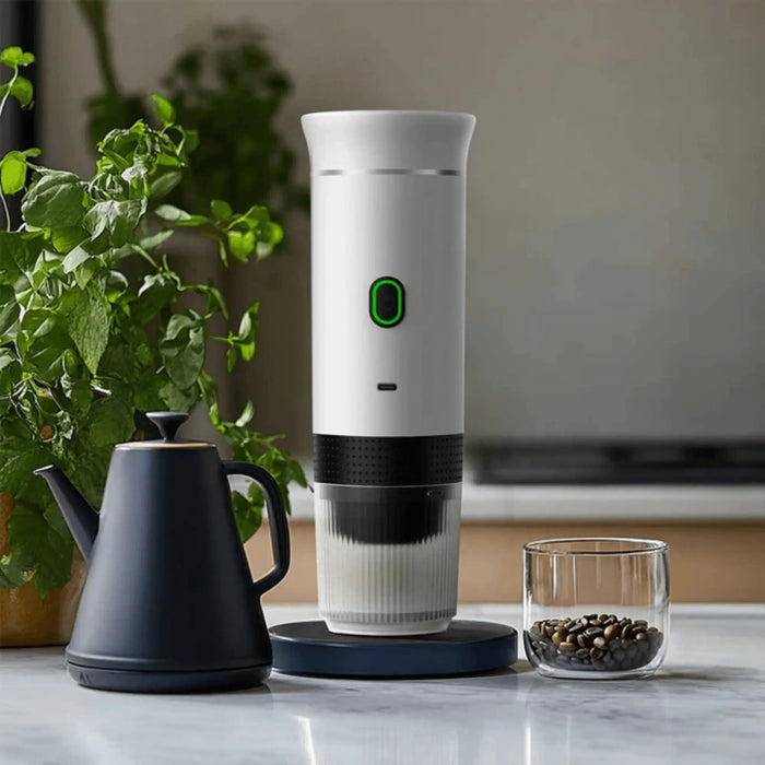 Machine à café électrique portable sur le comptoir de la cuisine avec des grains de café et une bouilloire.